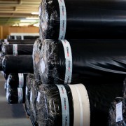 Rolls of meta-aramid high-performance Turbotec fabric wrapped in light protecting polythene, awaiting export to USA and India. Turbotec rolls wrapped in lightfast packaging awaiting despatch